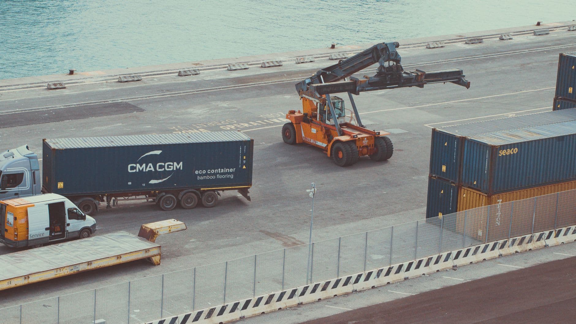 Drayage trucks lined up at a busy container port terminal