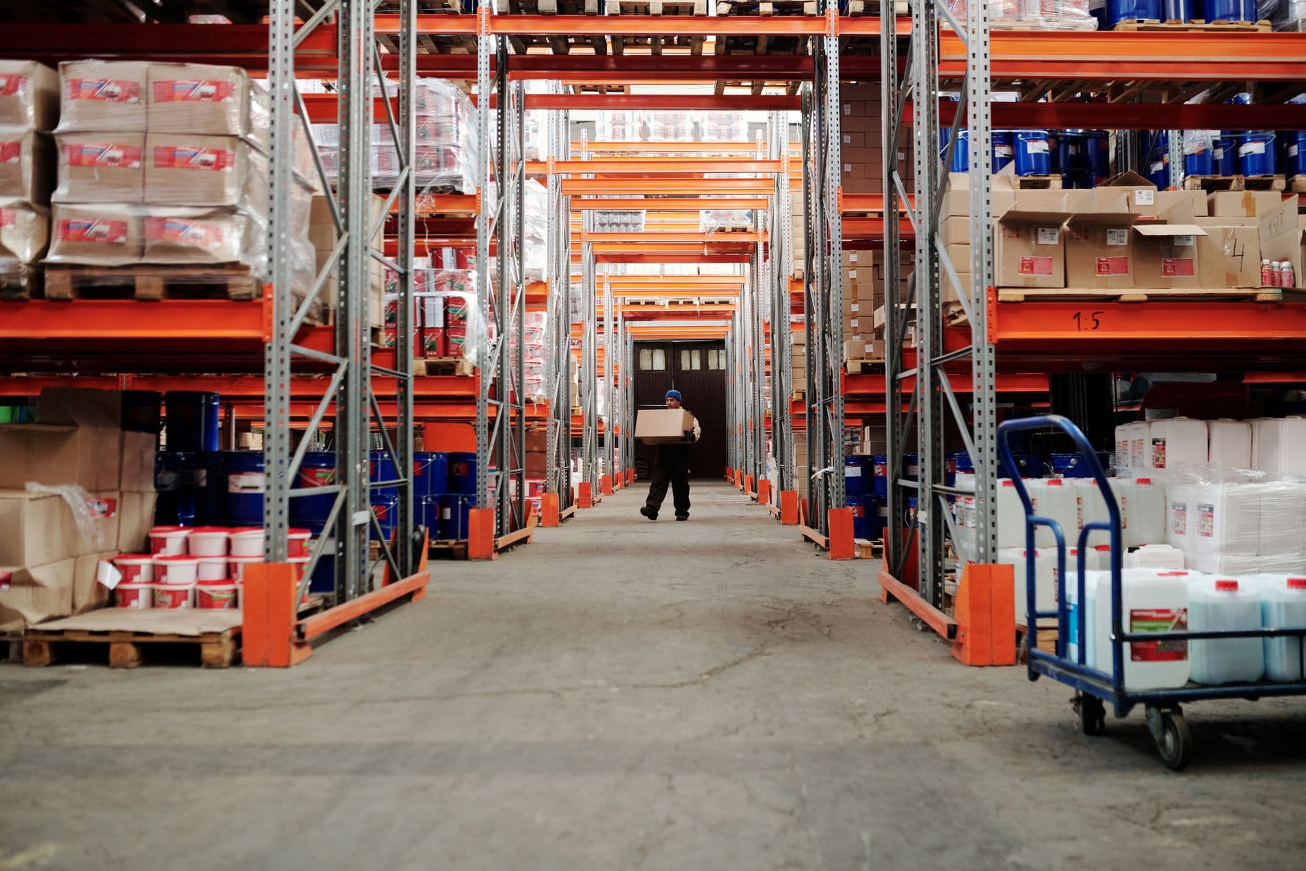 Wide-angle view of a fulfillment warehouse with tall shelving racks and palletized freight
