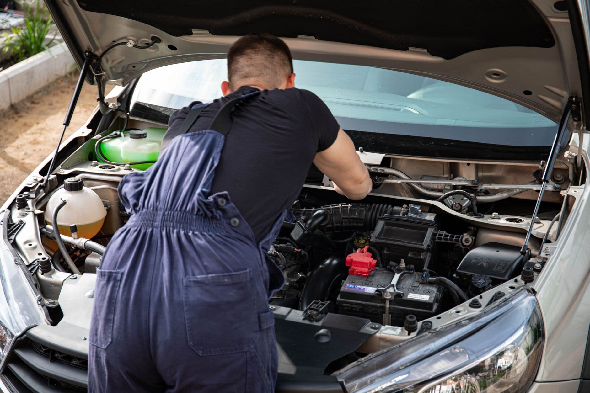 HVAC technician inspecting an outdoor air conditioning unit during summer peak season