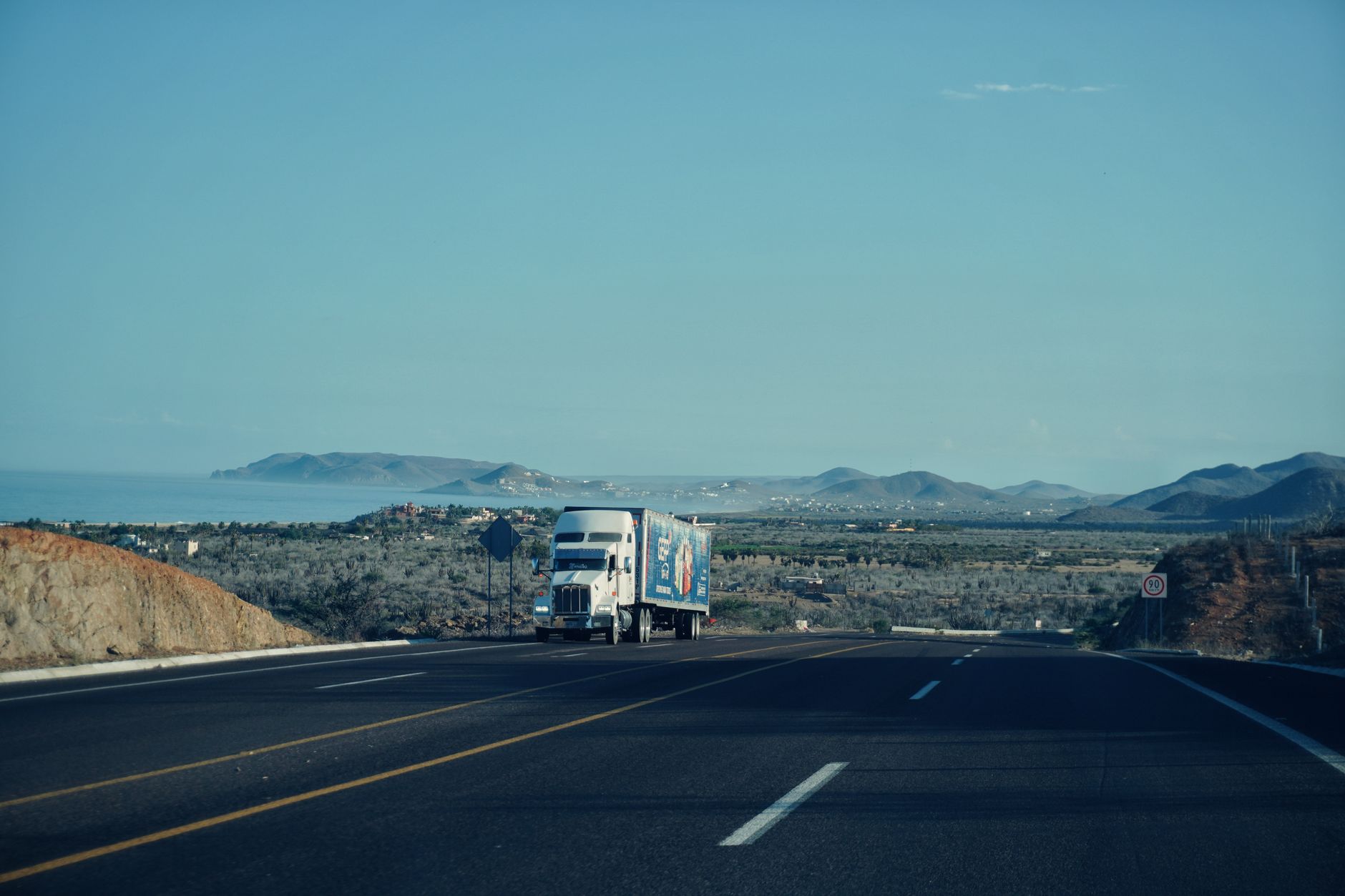 Semi truck driving on a major US highway representing active freight lanes